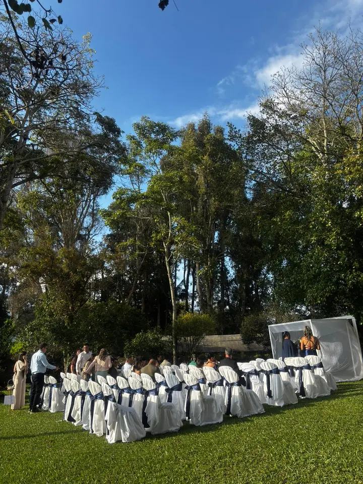 Sillas blancas para ceremonia en el jardín