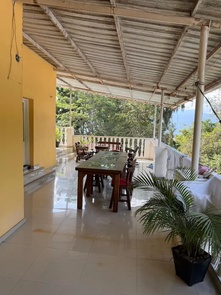 Balcón del hospedaje con comedor y vista a la naturaleza