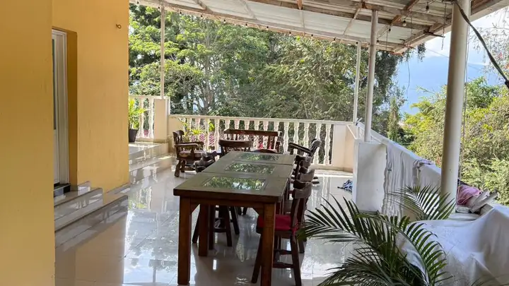 Balcón del hospedaje con comedor y vista a la naturaleza
