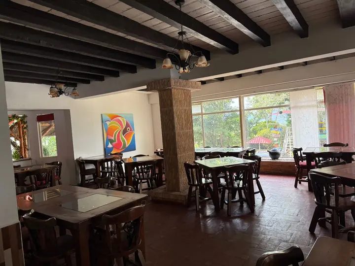 Restaurante Los Cayenos con mesas de madera y vista al jardín