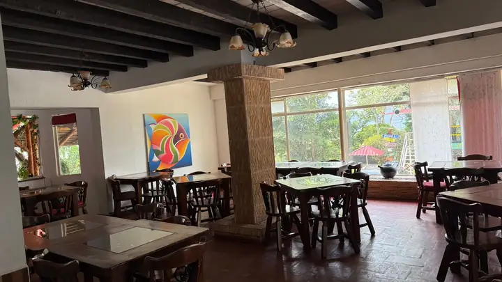 Restaurante Los Cayenos con mesas de madera y vista al jardín